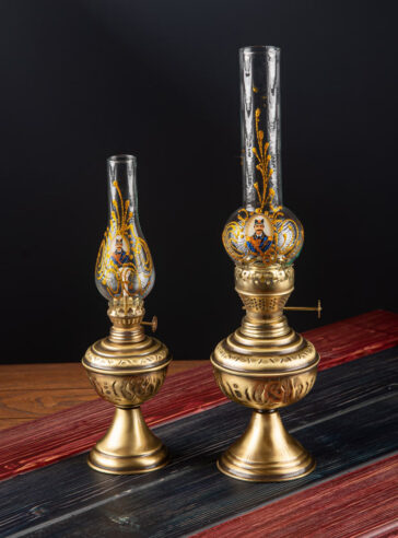 A set of two traditional decorative brass oil lamps with a royal pattern on the bubble