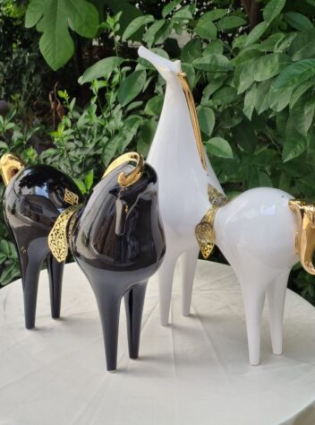 A pair of lustro-glazed ceramic horses  with brass saddles & 18 carat gold luster manes and tails