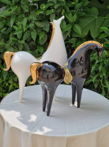 A pair of lustro-glazed ceramic horses  with brass saddles & 18 carat gold luster manes and tails