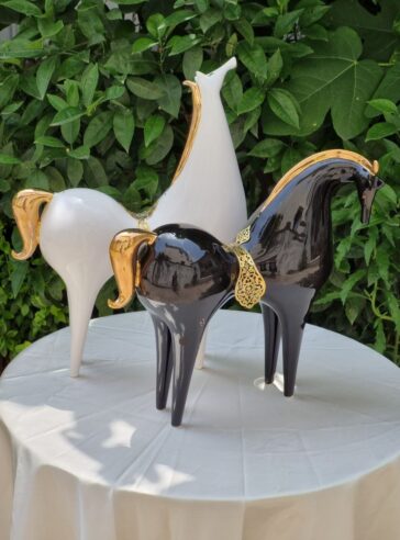 A pair of lustro-glazed ceramic horses  with brass saddles & 18 carat gold luster manes and tails